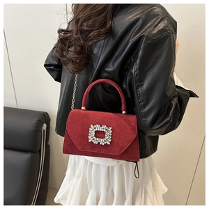 Détail du sac en daim bordeaux avec boucle en strass et bandoulière chaîne dorée