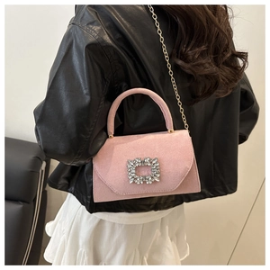 Dettaglio borsa in camoscio rosa con fibbia di cristallo e catena dorata elegante