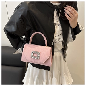 Dettaglio borsa in camoscio rosa con fibbia di cristallo e tracolla a catena