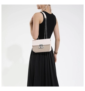 Chic pink leather and straw woven crossbody bag with silver chain strap worn by model