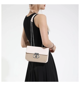 Detail view of woven texture and silver round lock on a two-tone chain crossbody bag