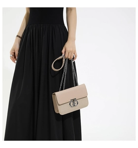 Detail showing beige contrasting textures and silver metal ring buckle on handbag