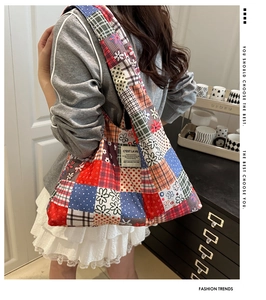 Detail of colorful patchwork canvas tote bag with floral patterns and wide shoulder strap
