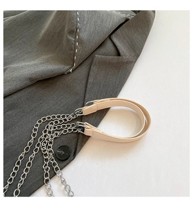 Detail of silver chain strap and creamy white leather handle for stylish women bag