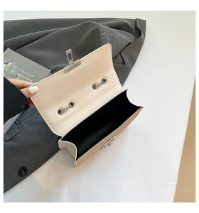 Detail of cream white textured shoulder bag showing interior space and silver clasp
