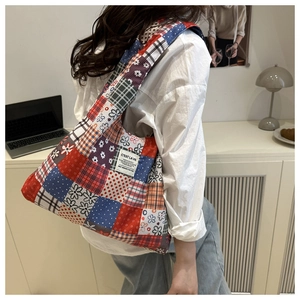 Gros plan d'un sac cabas en toile patchwork floral avec motifs variés et étiquette en tissu