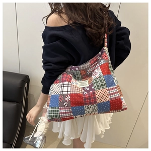Detail of the vintage patchwork canvas tote bag featuring quilted floral patterns and label