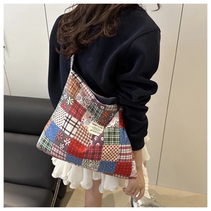 Detail of vintage patchwork shoulder bag with C'EST LA VIE label in a lifestyle scene