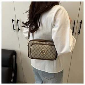 Vue détaillée du sac bandoulière rétro à monogramme avec le logo M doré sur le devant