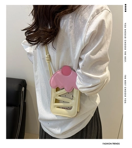 Detail view of cream cupcake crossbody bag with pink wave trim and hollow-out leather texture