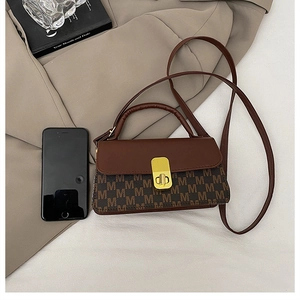 Mini brown leather crossbody bag with logo print and gold clasp shown with phone for size