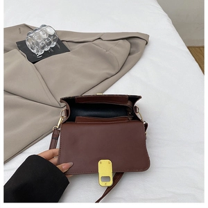 Close-up of the brown leather handbag interior with a zip pocket and metal clasp