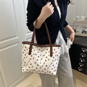 Fashionable cherry print tote bag with brown leather handles in a spacious design