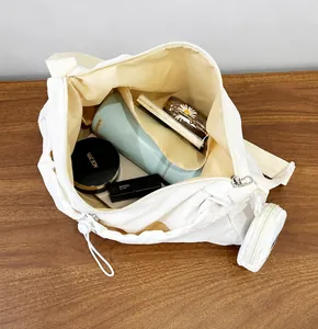 Internal view of white drawstring crossbody bag showing storage capacity for daily items