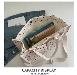 Detail show of canvas tote bag with red hearts featuring large capacity for tablet and umbrella