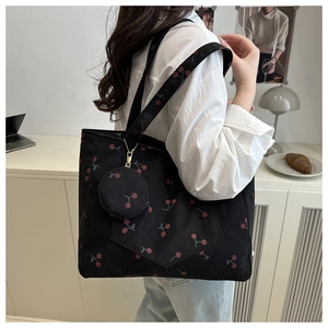 Détail du sac cabas en velours côtelé noir avec motif cerise et petit porte-monnaie assorti