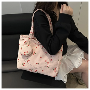 Pink corduroy tote bag with cherry print detail showing texture and small coin pouch