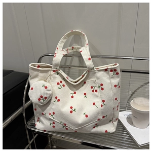 Détail du sac fourre-tout en velours côtelé avec motifs cerises et mini porte-monnaie