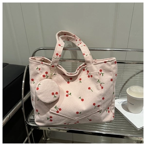 Détail du sac fourre-tout en velours rose avec motifs cerises et petit porte-monnaie