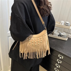 Bohemian light brown half-moon fringe bag with metallic studs on a female model