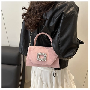 Détail du sac bandoulière en daim rose avec boucle à strass étincelante et chaîne dorée