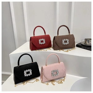 Detail showing four colors of suede crossbody bags with rhinestone buckles and gold chains