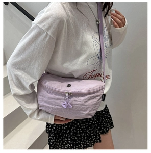 Detail of lavender nylon crescent bag with adjustable strap and metallic zipper