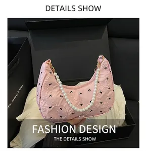 Sac sous le bras rose en forme de croissant avec imprimé nœuds et anse en perles