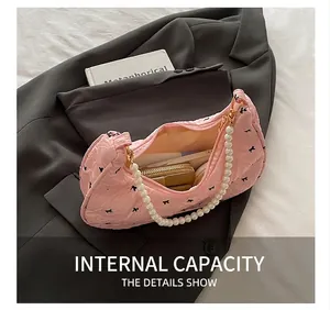 Vue intérieure du sac plissé rose avec imprimés nœuds et poignée en perles