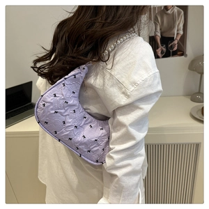 Détail du sac croissant lilas plissé avec texture florale et bandoulière perles