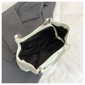 Detailed overhead view of spacious cream tote bag featuring silver rings and black lining