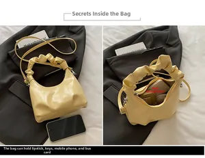 Detail view of the yellow pleated crescent bag showing internal storage for phone and keys