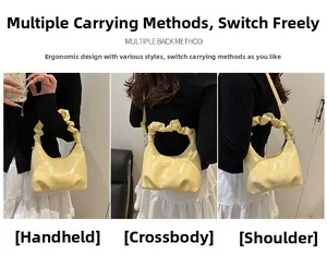 Detail of pale yellow glossy PU leather handbag with ruched handle and chain strap