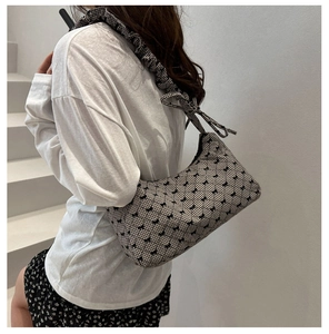 Detail of checkered shoulder bag with scrunchie strap and delicate bow accents