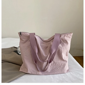 Detail of light purple nylon tote bag showing its unique wrinkled texture and wide straps