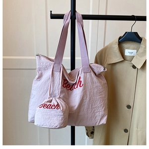 Pink fabric tote bag with red Beach lettering and matching drawstring mini pouch