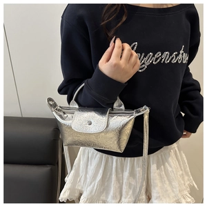 Detail of silver textured mini crossbody bag with foldover flap and thin strap