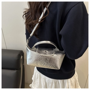 Micro metallic silver handbag shown on a model with glossy embossed texture