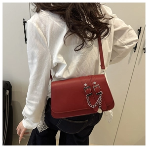 Détail du sac sous l'aisselle rouge foncé avec chaîne argentée et doubles boucles