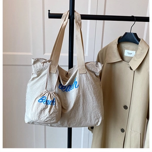 Detailed view of beige tote bag with Beach print, including matching drawstring pouch