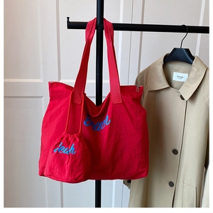 Detail of red tote bag with Beach embroidery and matching drawstring inner pouch