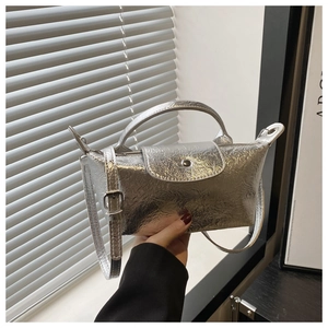 Detail of silver metallic dumpling bag with pleated mirror texture and pearl handle