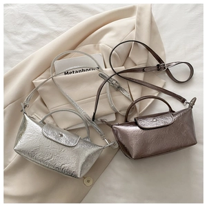 Detail of mini dumpling bags in silver and bronze with metallic crinkled leather texture