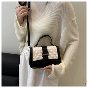 Chic quilted crossbody bag in black and cream worn by model with silver buckle