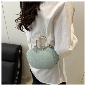 Macro shot of light blue embroidered shell bag with gold handle and pearl detail