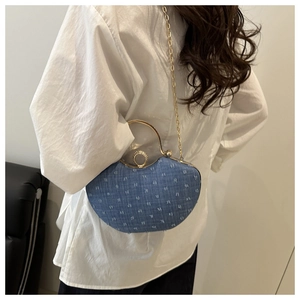 Detail of blue denim heart bag with gold ring handle and sparkling rhinestone buckle