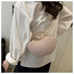 Detail of elegant evening clutch featuring rhinestone handle and large pearl clasp decoration
