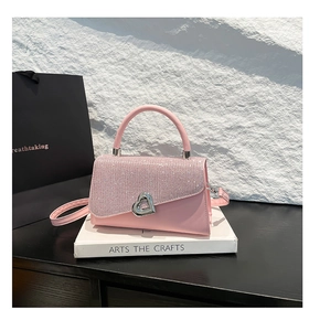 Detailed view of pink leather bag with crystal rhinestones and heart-shaped silver clasp