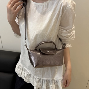 Metallic bronze pleated mini dumpling bag with top handle and adjustable crossbody strap