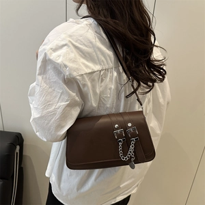 Petit sac vintage marron foncé porté à l'épaule avec boucle métallique et chaîne décorative